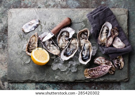 Oysters on stone plate with ice and lemon Royalty-Free Stock Photo #285420302
