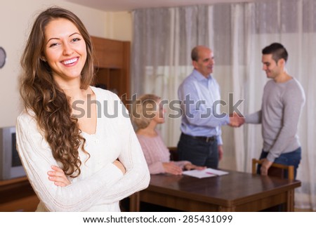 Happy adult girl staying near united family members