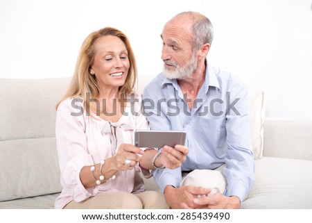 Happy elderly couple looking at a tablet