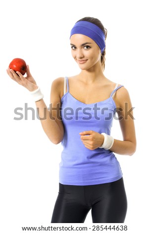 Portrait of woman in violet sportswear with red apple, isolated against white background. Young sporty dark-haired model at studio shot. Health, dieting and fitness concept.