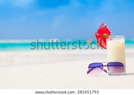 picture of fresh pina colada and sunglasses on tropical beach