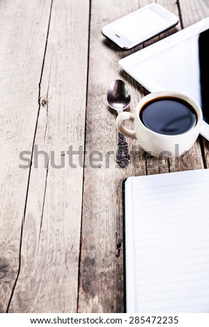 desk with a cup of coffee, a notebook and pen