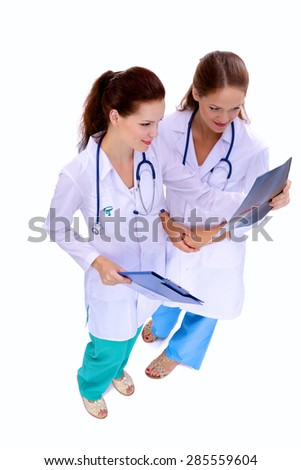 Two woman nurse watching X Ray image, standing in hospital.