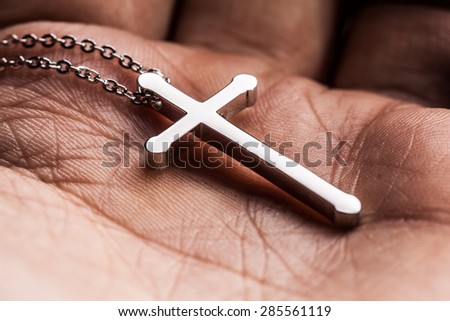 Silver cross in a hand  close up image