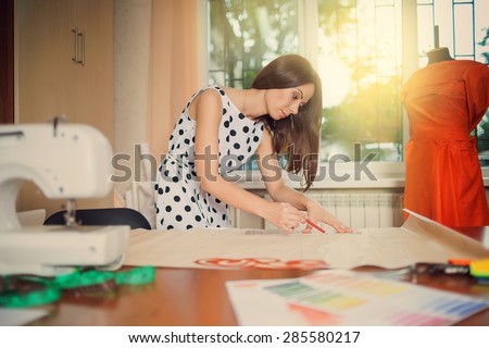 young designer making a garment in her workplace
