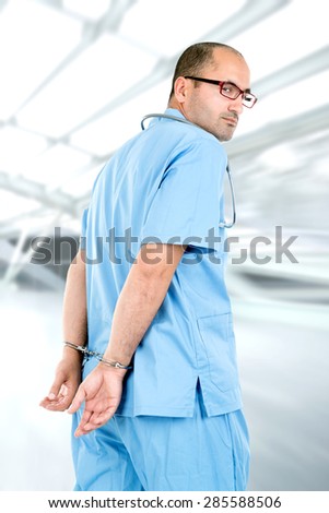 Male doctor in uniform with handcuffs being arrested