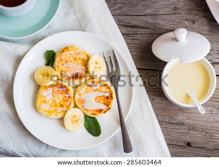 Homemade cottage cheese pancakes  with banana, condensed milk and fresh mint, gray wooden background, breakfast,top view Royalty-Free Stock Photo #285603464