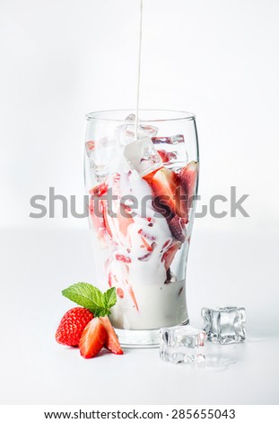 Strawberry with milk in glass on white background