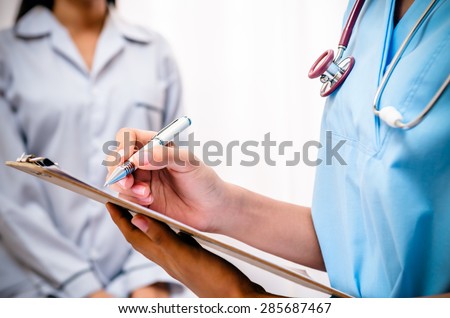 surgeon writing patientâ??s record after examine health Royalty-Free Stock Photo #285687467
