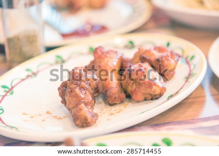 A plate of chicken wings with barbecue sauce -Vintage picture style 