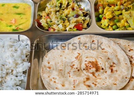 Selective sharpness picture of the tray with Indian dish thali, subji, rice and chapati bread