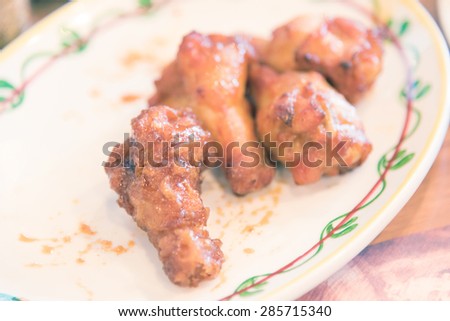 A plate of chicken wings with barbecue sauce -Vintage picture style 