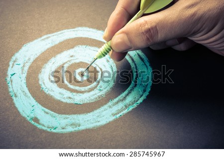 Set goal or accurate planning, hand take a dart into the center of sketching dartboard Royalty-Free Stock Photo #285745967