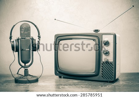 Retro television, old microphone from 50s and headphones. Vintage style sepia photo