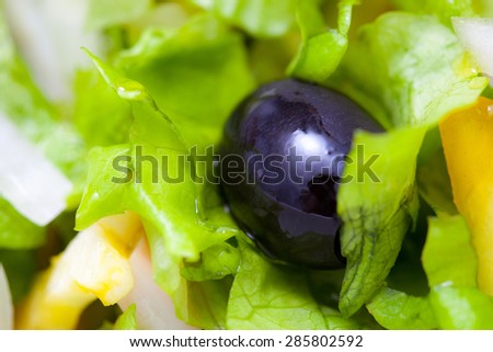 black olives and lettuce, close-up. small deph sharpness
