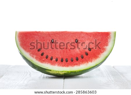 Slice of watermelon with seeds that make a smiling face Royalty-Free Stock Photo #285863603
