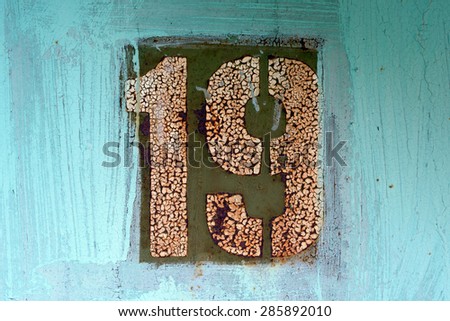 White number 19 on old painted  and rusted metal panel 