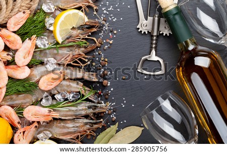 Fresh prawns with spices and white wine on black stone background. Top view with copy space