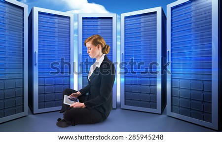 Redhead businesswoman using her tablet pc against composite image of server room
