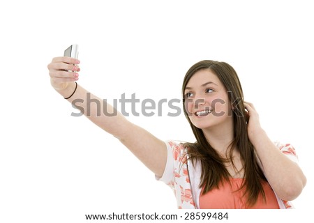 Caucasian teenager using a cell to take a pictue of herself on white background