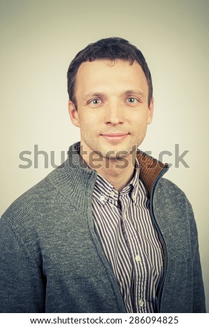 Smiling young Caucasian man in casual clothing, studio portrait with vintage tonal correction photo filter effect, instagram old style