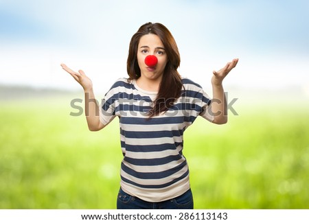 Confused woman with clown nose. Over nature bokeh background