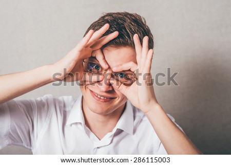 Concentrated businessman making binoculars with hands and looking through