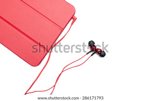 Red tablet and earphone plugs isolated on a white background