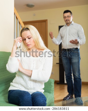 Sad married couple after quarrel in living room at home Royalty-Free Stock Photo #286183811