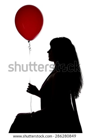 Photo of sitting woman's silhouette with red balloon in profile on white background