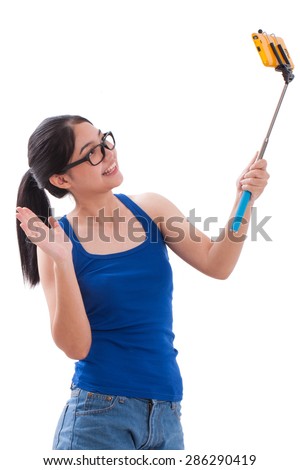 Happy woman taking picture with smartphone selfie stick