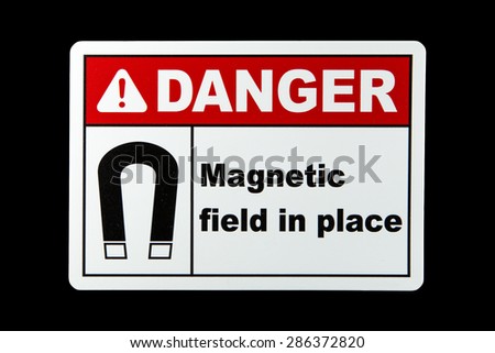 A magnetic field danger sign against a black background