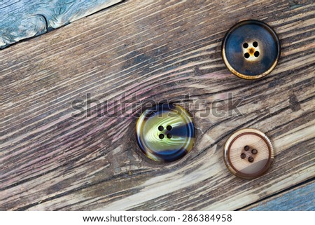 three aged buttons on old tailorÃ¢??s table