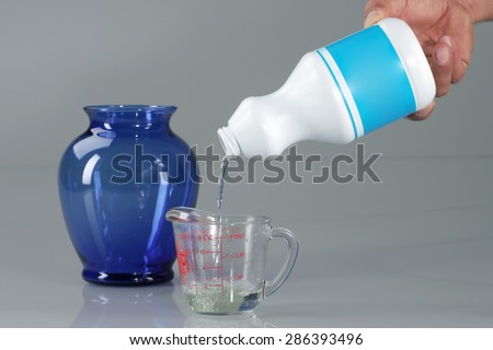 Pouring Bleach on Measuring Cup Royalty-Free Stock Photo #286393496