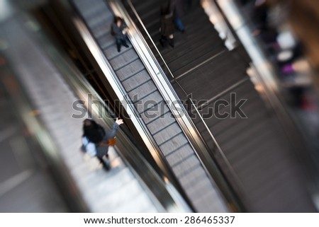 Commuters on an Escalator inside a Station or Airport