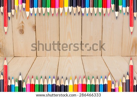 Frame of Colour pencils with shadow on wood texture background
