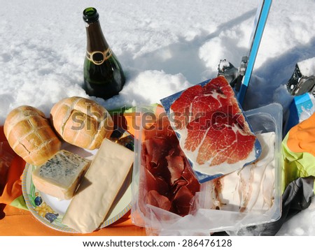 pic nic on the snow with typical mountain food sausages and cheeses