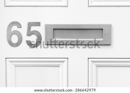 Door number 65 sixty five and letterbox conceptual image closeup