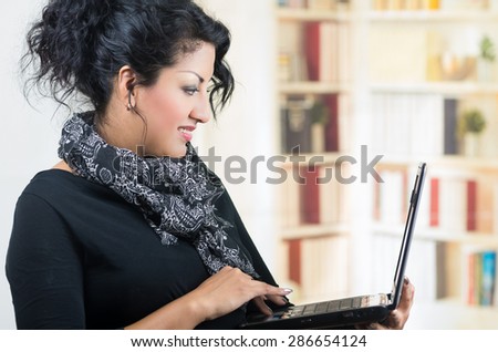 closeup woman wearing casual clothes holding laptop working