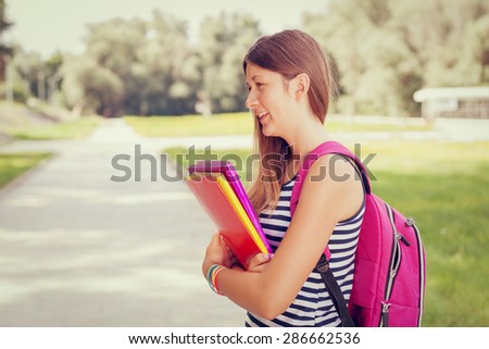 Beautiful student girl with backpack and books going back to school