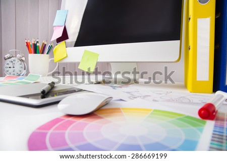 Modern office workplace with digital tablet, notepad, colorful pencils, glasses, in morning