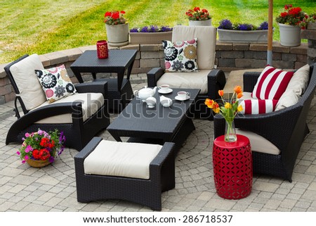 Overview of Upscale Patio Set, Dark Wicker Luxury Furniture with Comfortable Cushions on Outdoor Stone Patio of Affluent Home