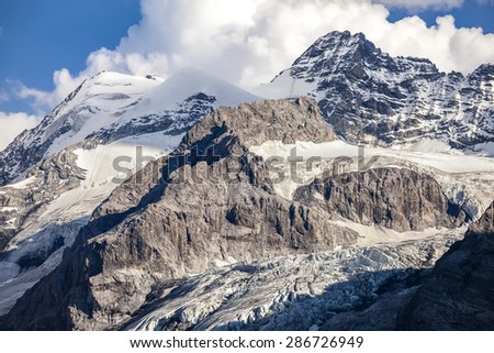 Icy mountain peak and clouds in the blue sky