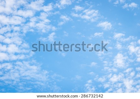 Blue blurred sky background with natural soft scattered clouds pattern texture with heart shaped space in the air