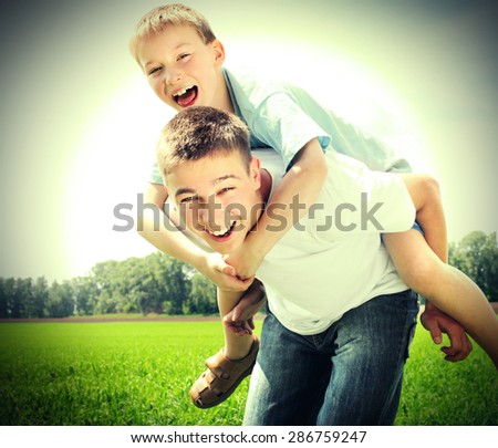 Vignetting Photo of Happy Brothers playing in the summer field