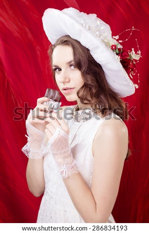 Pretty girl in retro clothes eating chocolate and enjoying looking at camera, closeup picture