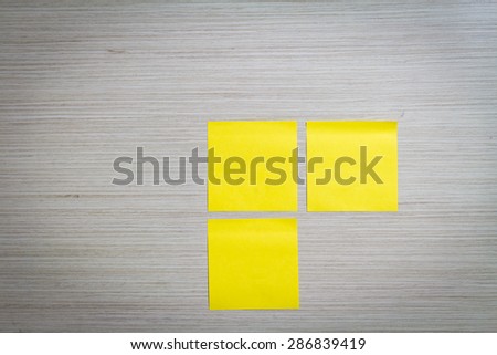 Yellow sticky note attach to a wooden wall