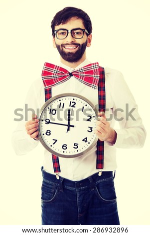Funny man wearing suspenders holding big clock.