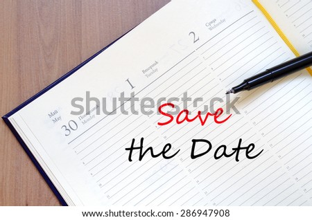 Yellow blank notepad on office wooden table Save the date concept