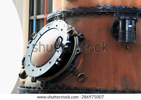 Door on a copper gin kettle in a distillery. Royalty-Free Stock Photo #286975007